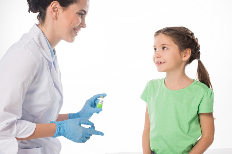 Smiling pediatrician with hpv vaccine looking at kid isolated on white