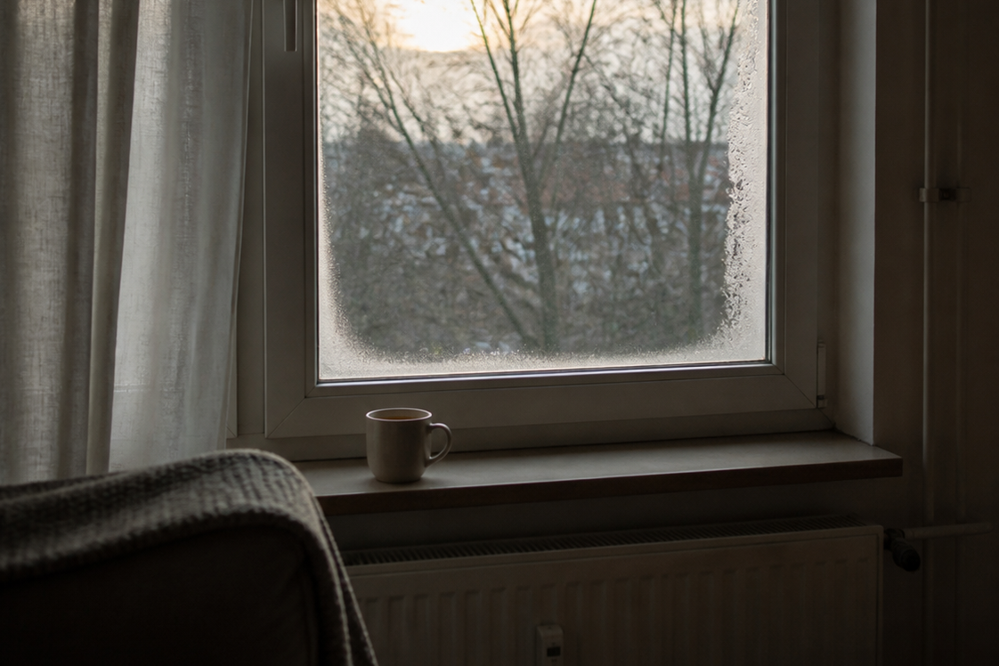 Grauer Wintertag hinter dem Fenster, Tee auf der Fensterbank